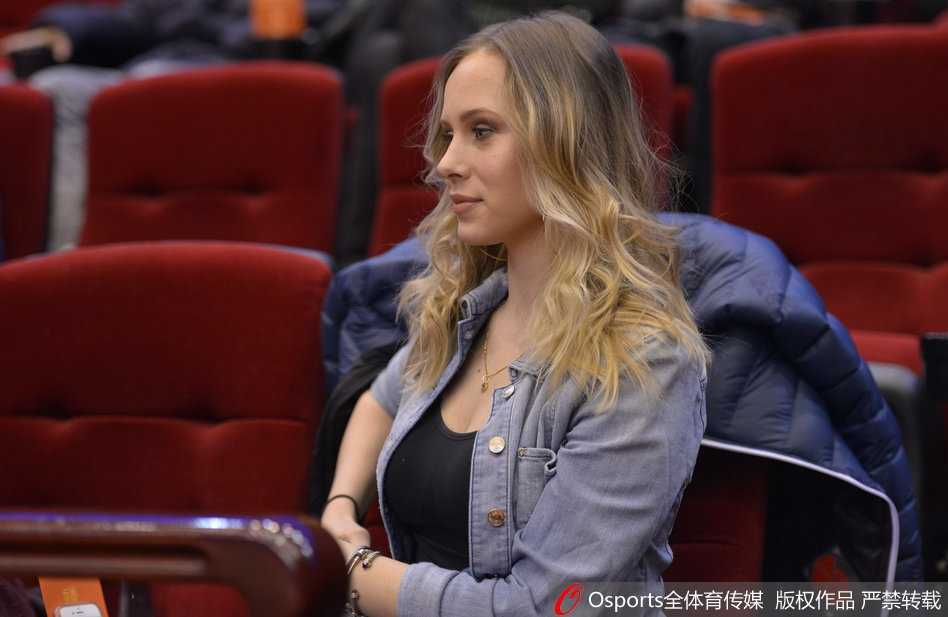 喧嚣的看台一角因她而静谧，手中的福字与她身上散发的柔和气息融为一体，那抹笑意里既有为人妻的温婉，也有一丝少女般的俏皮，宛如童话中走出的冰雪女王。