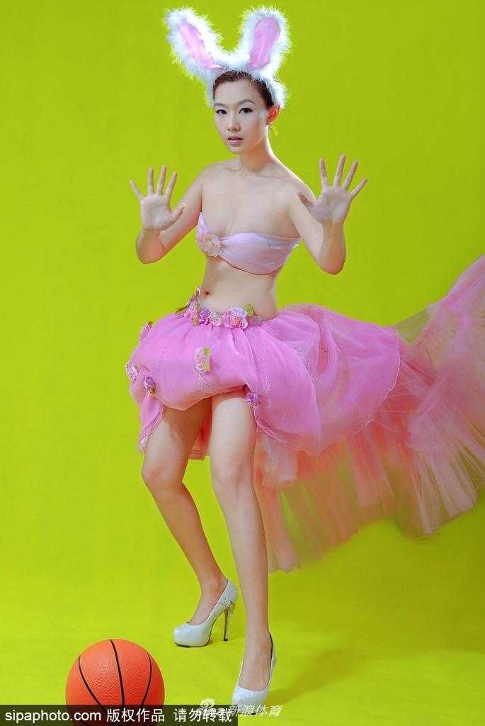 刘闻雯侧身回眸，黑色兔女郎装扮勾勒出她高挑玲珑的身材曲线，眼神中带着一丝慵懒与妩媚，将运动场的活力与女性的柔美融为一体。