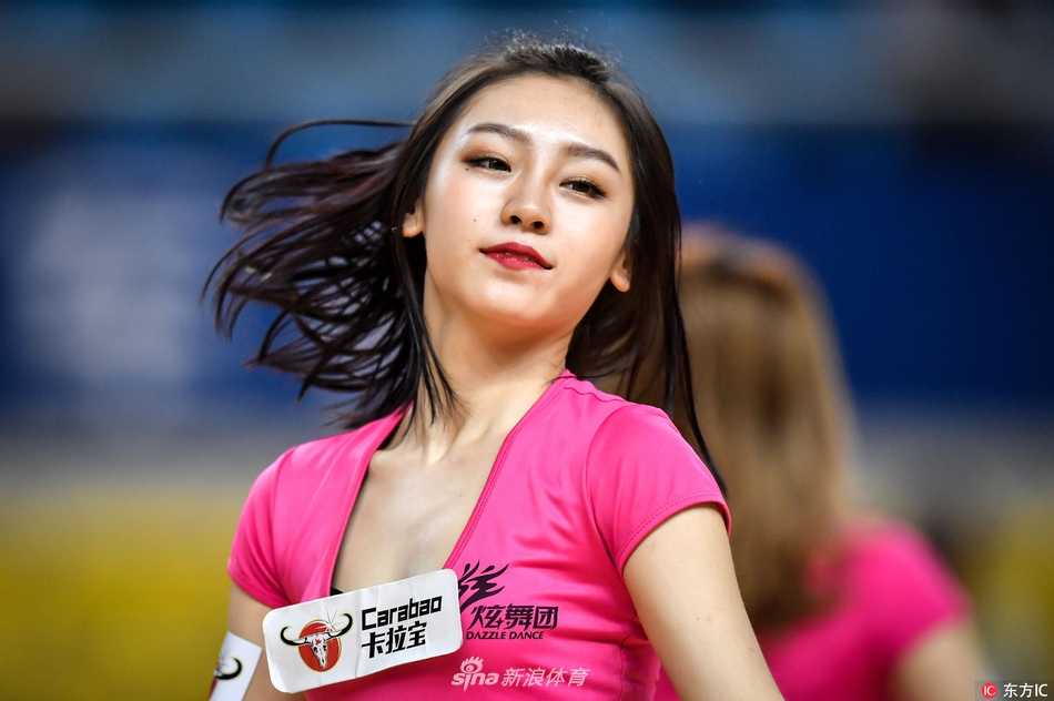 特写镜头中，这位啦啦宝贝的笑容极具穿透力，仿佛能驱散一切疲惫。她手中的花球如同被施了魔法，在聚光灯下闪烁着迷人的光彩，与她眼中的星光交相辉映。