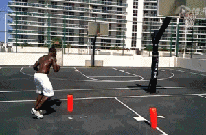 球员背身护球，突然以右脚为轴，如陀螺般转身抹过防守，面筐直杀篮下