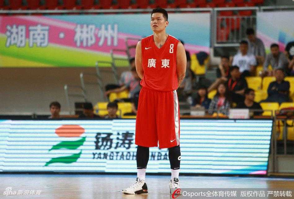 朱芳雨与顾全在场边交流战术，朱芳雨神情专注，用手指点着场上的形势