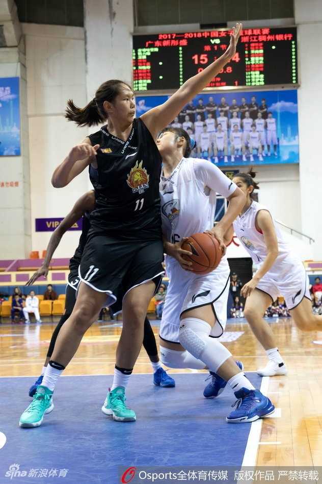 广东队中锋李月汝在浙江队多人包夹防守下，依然高举高打，试图完成一记势大力沉的双手灌篮，眼神中透露出必胜的决心。