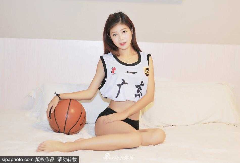 广东女孩身着休闲装，在洒满阳光的卧室里与篮球亲密互动，眼神中透出对篮球的纯粹喜爱