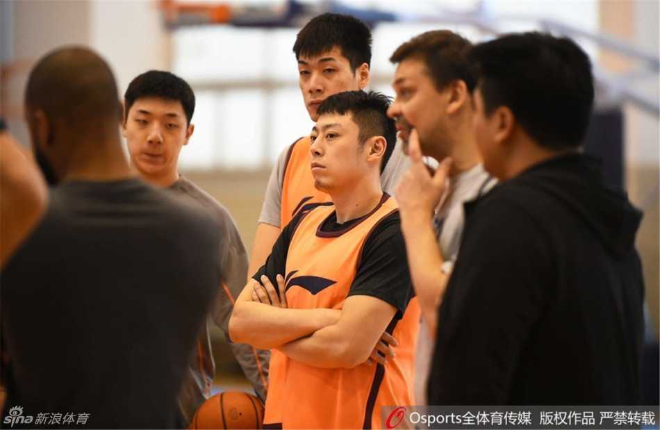 布泽尔在罚球线附近稳稳出手，篮球空心入网，他的眼神专注而坚定，身后的训练师正等着为他捡球。