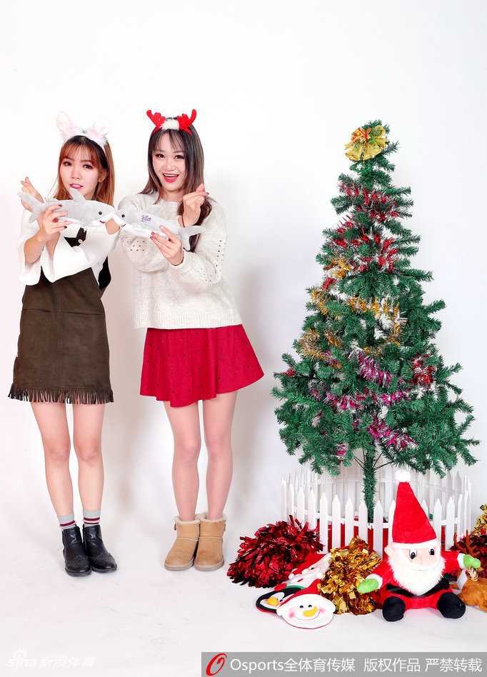 姑娘双手托腮，露出乖巧可爱的表情，红色蝴蝶结发饰与身上的圣诞裙装相得益彰