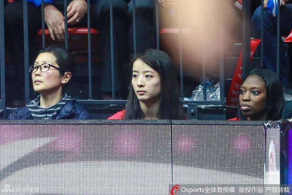 另一角度展示两人观战的投入状态，亚当斯女友表情更为外露兴奋，孙桐林妻子则抿嘴微笑，性格差异一目了然。