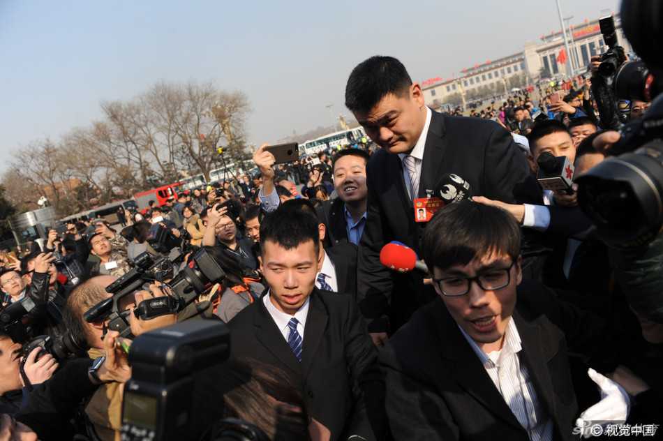 政协体育界别小组讨论开始前，姚明侧身与邻座委员认真交流，神情专注而严肃，为新身份下的首次两会发言做准备