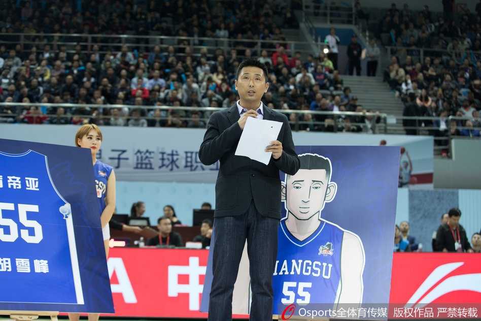 胡雪峰手捧鲜花，身旁摆放着他获得的各类奖杯与纪念奖牌，此刻他不再是赛场上冲锋陷阵的战士，而是光荣退役的功勋。