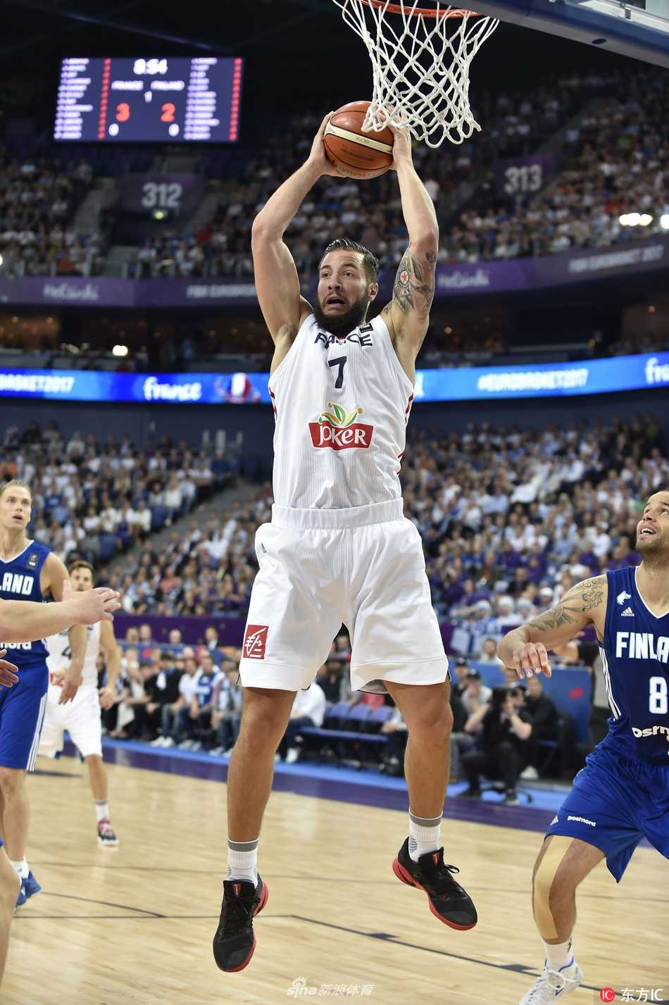 法国队后卫德科洛在芬兰球员的严密包夹下，奋力护球，脸上写满了焦急与不屈，比赛强度可见一斑。