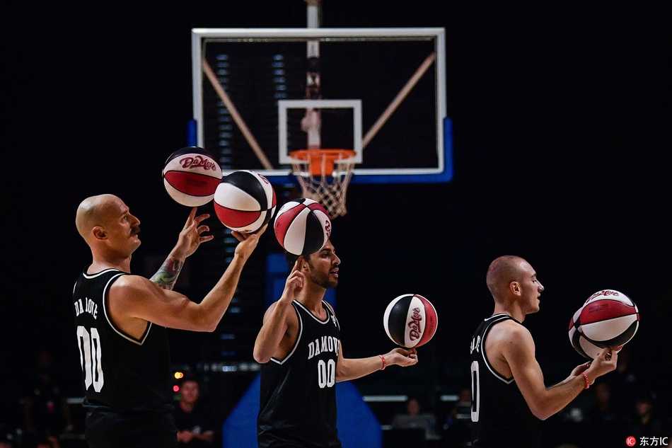 表演者全神贯注，篮球如同被施了魔法般在指尖飞速旋转，背景是模糊的球场灯光与观众席，这一刻，技巧与艺术完美融合。