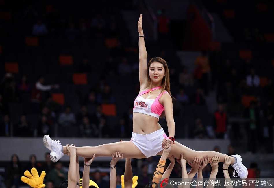 宝贝们倚靠在场边栏杆，粉色的衣角与背后的宏远队徽交相辉映，构成一幅动感的体育画卷