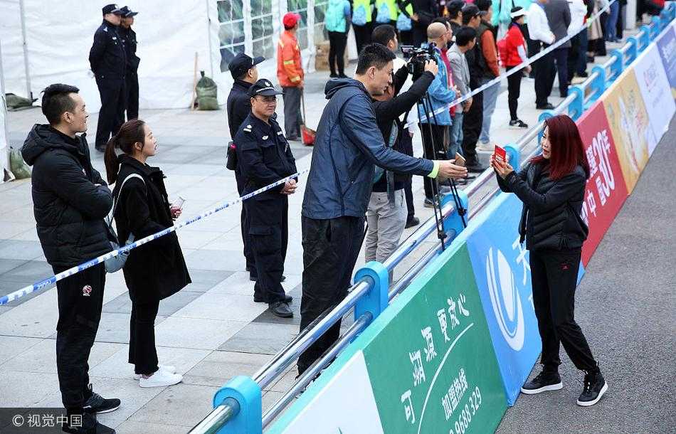 杜锋穿着一身深色运动休闲装，面带微笑地低着头操作手机，屏幕上正是他的个人二维码。站在他对面的冬日那身体微微前倾，耐心等待着这跨越体育项目的“连线”完成。