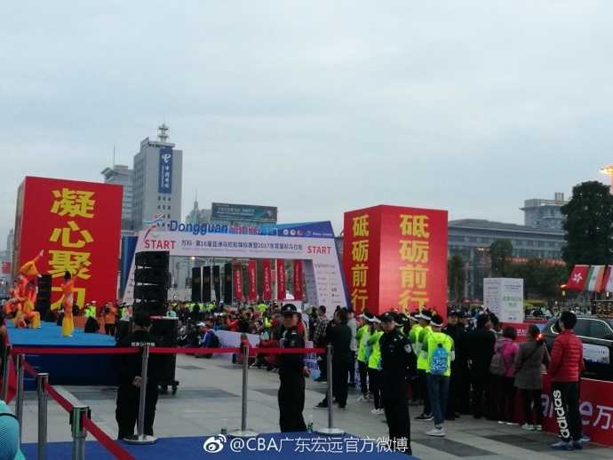 广东宏远队的球员们集结在马拉松队伍中，他们身着长袖运动装，如同移动的高塔，与身边普通身材的跑友形成有趣对比，每个人的脸上都洋溢着参与全民健身的兴奋与好奇。