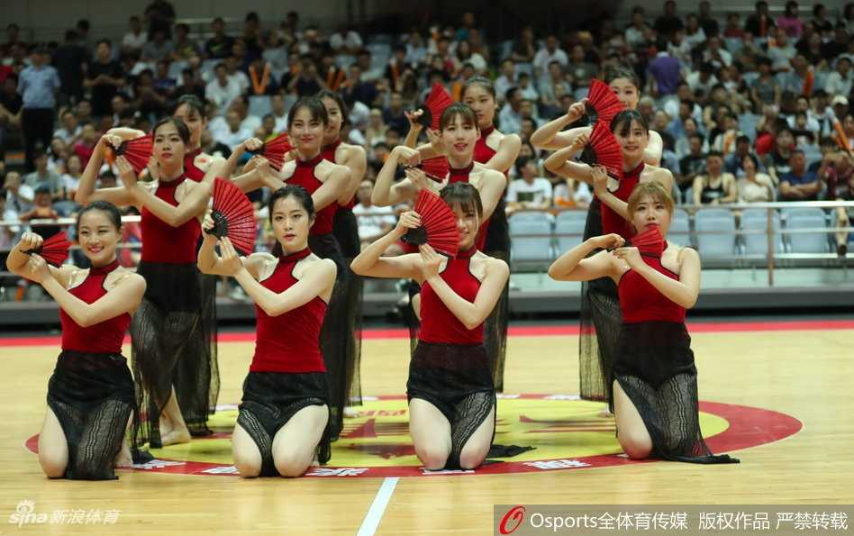 蕞红啦啦队队员身穿透纱红裙赤脚起舞，折扇半掩面，高挑身姿若隐若现