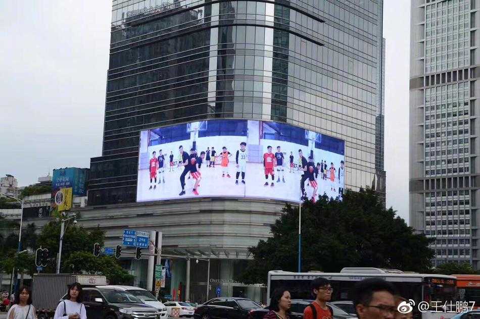 赛场上一位薪火小球员高高跃起投篮，汗水在空中飞扬，背景里是同样全力以赴的对手与充满期待的观众