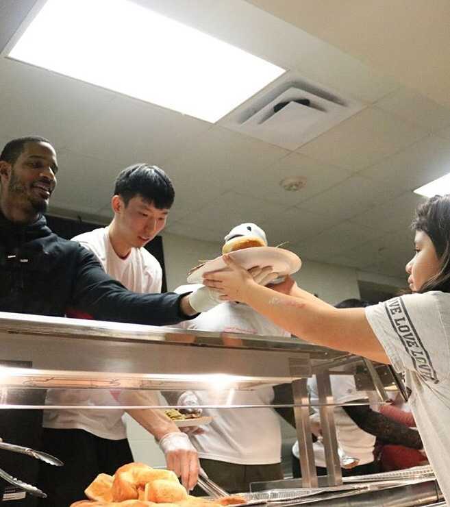 周琦与阿里扎并肩站在厨房的操作台前，身前摆放着金黄色的烤火鸡，两人面对镜头，眼神中透露出对即将到来的节日大餐的期待。