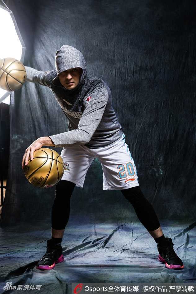 西热力江目光如炬凝视前方，身着时尚嘻哈卫衣，背景是暗色调的都市街头，仿佛在静候对手的挑战