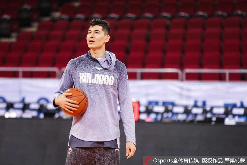 西热力江在助教的协助下进行拉伸训练，肌肉线条分明，神情专注而放松，展现了职业球员对身体管理的极致追求