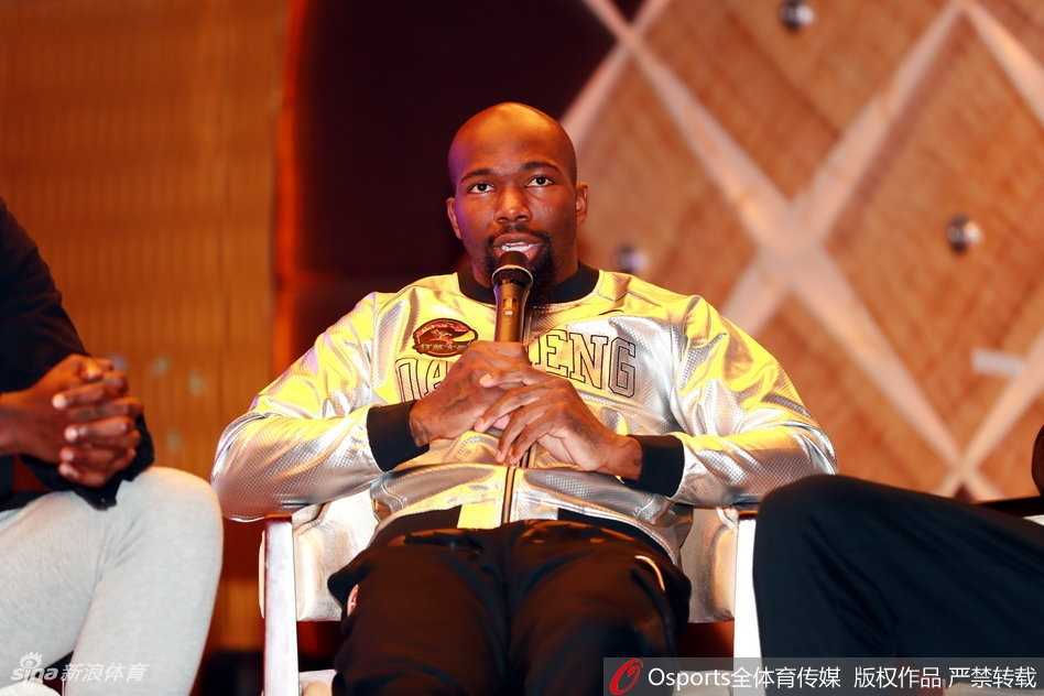 郭昊文与邬挺嘉并肩站立，郭昊文一身浅灰色双排扣西装显得肩宽腿长，正侧头与队友交流，邬挺嘉则认真倾听，两人手中都握着印有全新Logo的篮球。