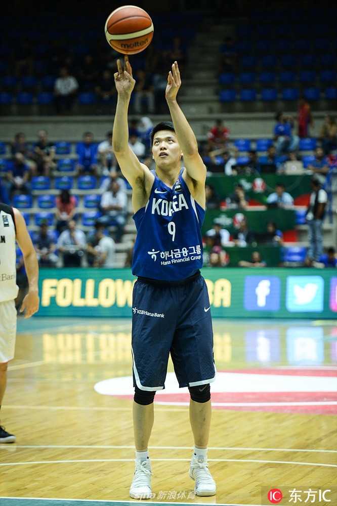 韩国队后卫在几名日本球员的围堵下，依然眼神坚毅地寻找着队友的接应点，场边替补席队友纷纷起立紧张观战。