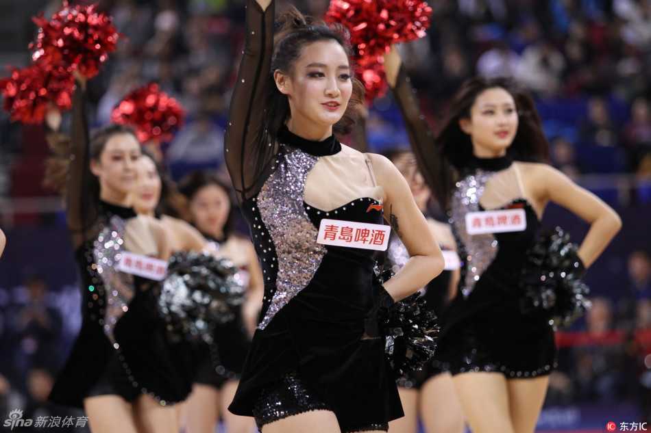 两位牛仔打扮的啦啦宝贝相视而笑，高马尾显得活力十足，修长笔直的双腿在舞台灯光下格外耀眼，笑容里满是青春自信。