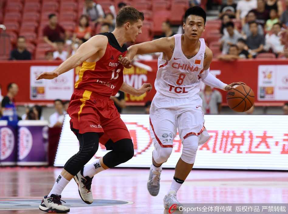 易立蹲在球员中间，手持战术板画着战术路线，队员们俯身低头认真聆听。