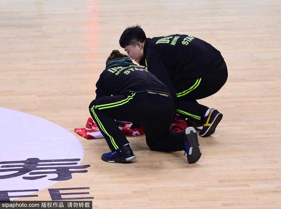 激烈的比赛间隙，辽宁队主帅郭士强布置战术，背景中是快速就位的场地清洁人员，他们共同构成了赛场内外的战斗集体