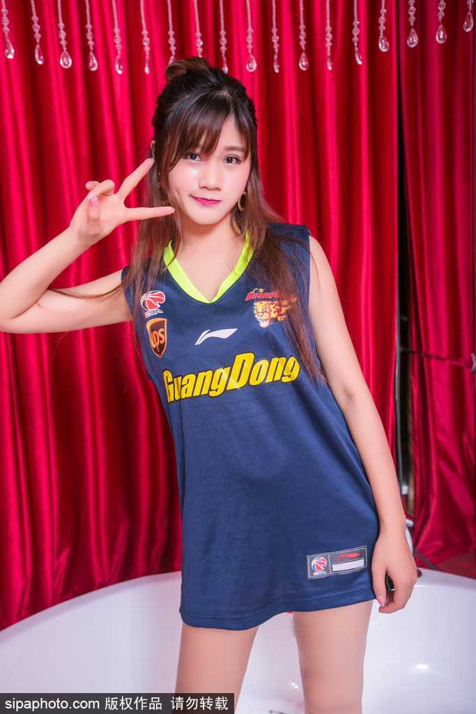 她跪坐在地，笑容甜美而治愈。简洁的运动背心展现出健康的力量感，整个画面洋溢着青春独有的朝气与美好，让人忍不住多看几眼。