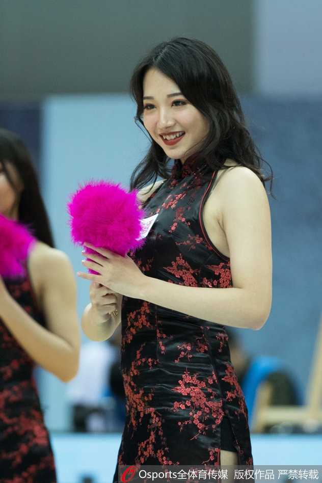 灿烂的笑容在聚光灯下格外耀眼，她用双手在头顶比出爱心，将这份热情毫无保留地传递给看台上的每一位球迷。