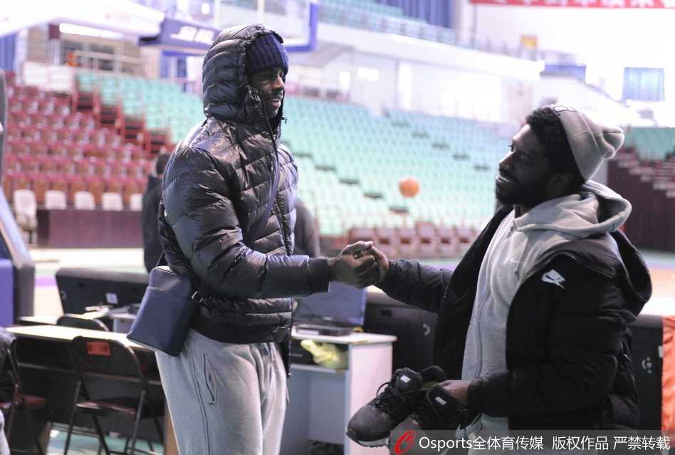 辽宁队大外援巴斯在训练场边露出憨厚笑容，眼神中透露出对老友重逢的喜悦。