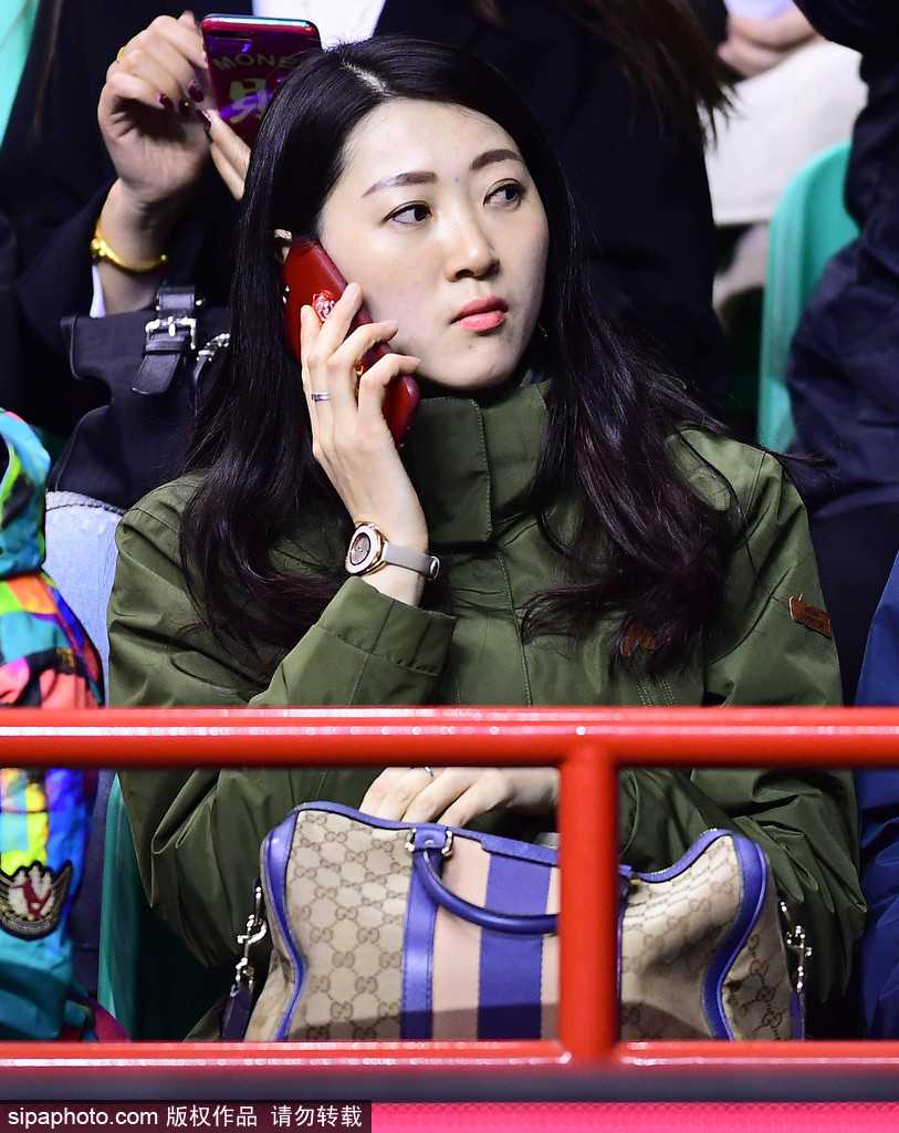 在人群之中，孙婉晴拿出手机记录下赛场的精彩瞬间，她身后的球迷们或欢呼或紧张，而她依然保持着那份独特的宁静与优雅，仿佛想把这一刻的美好永远留存。