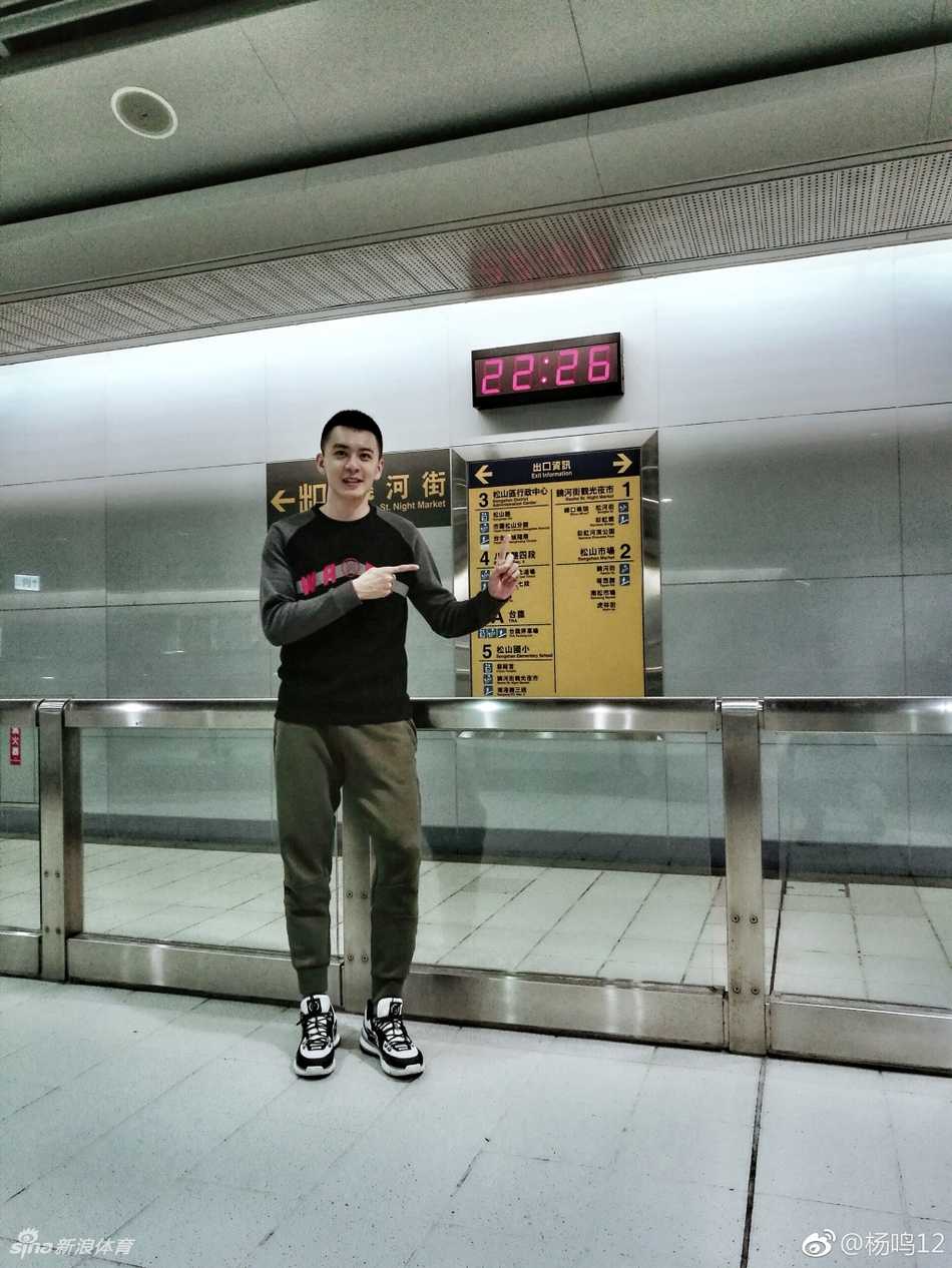 夜市的暖黄灯光温柔地勾勒出杨鸣的轮廓，他眼神温柔地望向镜头，身后是充满宝岛风情的美食摊位，空气中仿佛都弥漫着大肠包小肠的诱人香气。