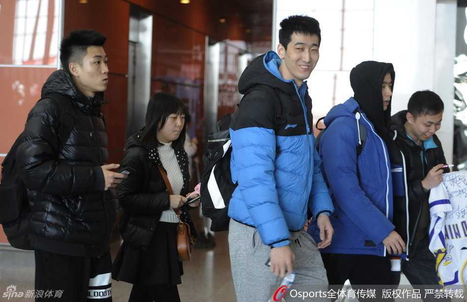 哈德森一边推着行李箱，一边与赵继伟玩起击掌游戏，两人表情搞怪，身后的李晓旭和钟诚也露出灿烂笑容