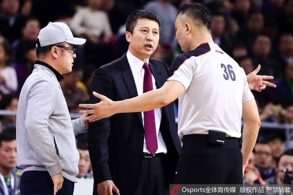 在嘈杂的首钢体育馆内，郭士强双手插兜，目光如炬地注视着裁判。他不再咆哮，但那份沉默中蕴含的力量更令人动容。辽宁队员哈德森站在一旁，神情略显无奈，师徒二人在这一刻共同承受着比赛带来的压力与不公。