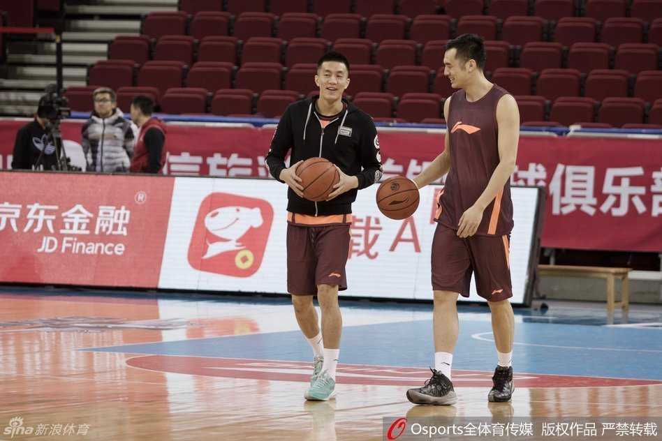 郭艾伦和韩德君并排坐在场边休息，两人一边擦汗一边交流着训练中的心得，场下的友谊是场上默契的基石。