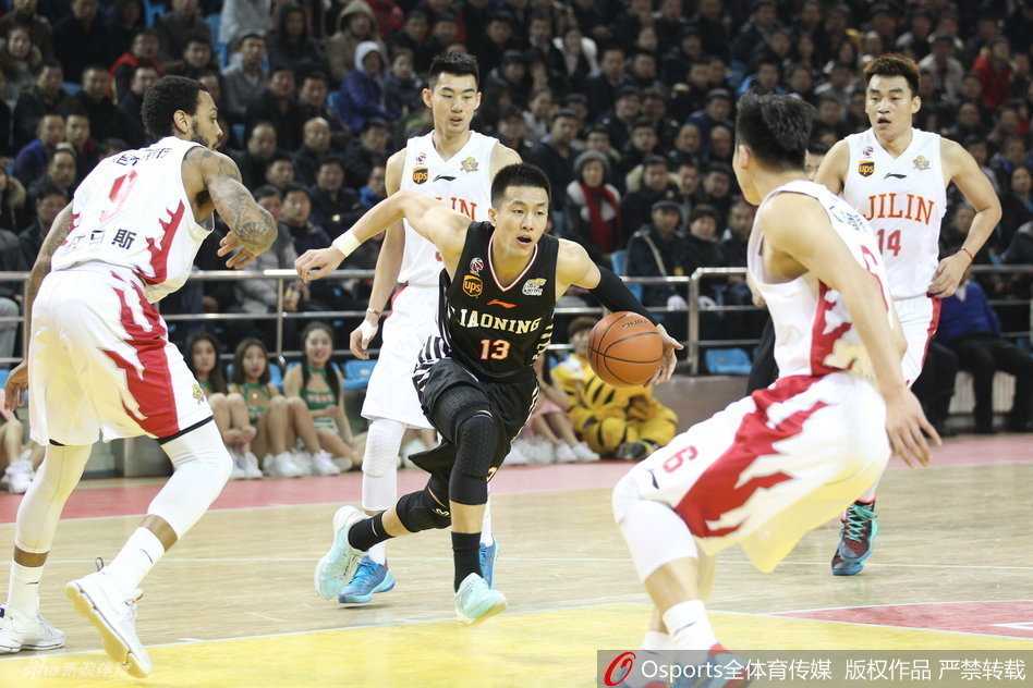 郭艾伦高高跃起，手指轻柔地将球拨向篮筐，小抛投的瞬间，他的身体在对抗后微微后仰，眼神紧盯着旋转的篮球