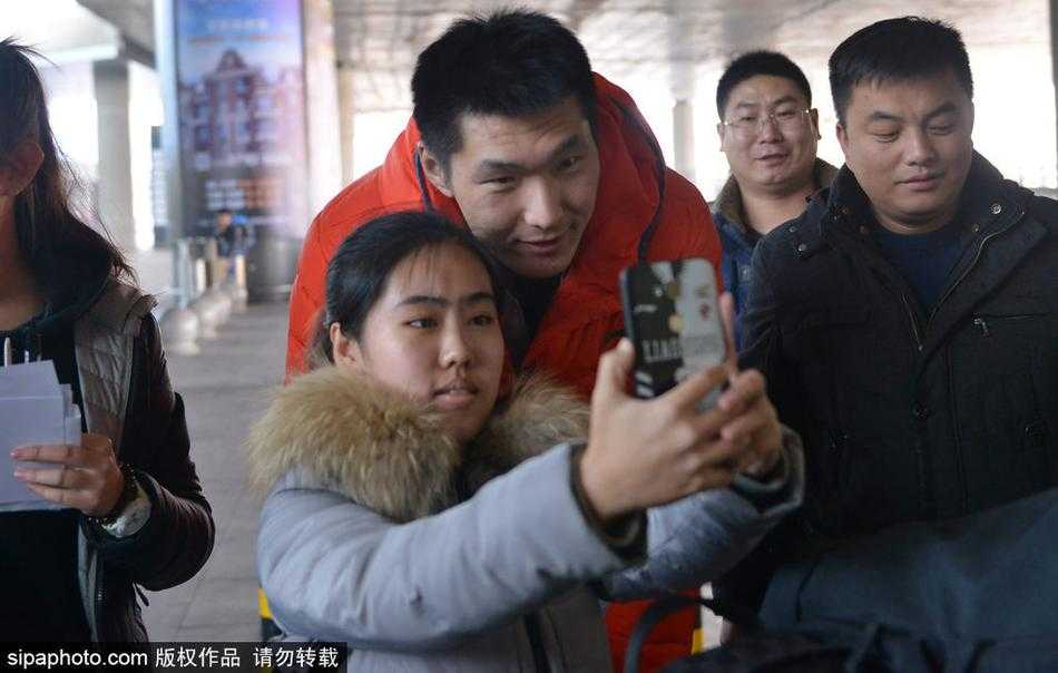 走出拥挤的人群后，郭艾伦终于可以放松一下，他低头看着手中的球迷礼物，眼神中充满感动。