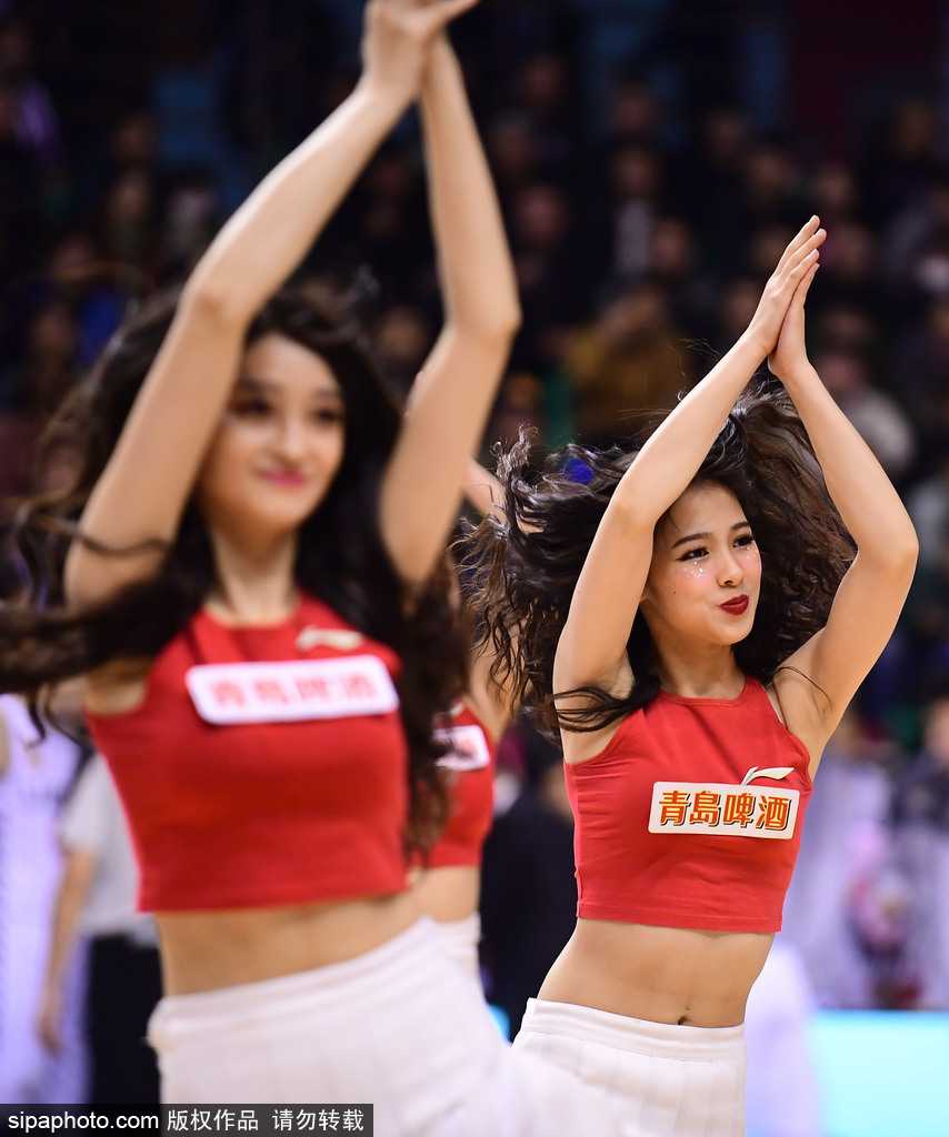 手持助威花球的宝贝回眸瞬间，眼神中带着俏皮与坚定，身后的巨幅辽宁队徽与她娇小的身影形成对比，却丝毫不减其赛场的存在感。