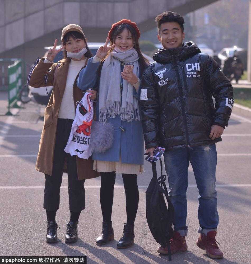 迷妹的漫长等候,只为CBA赛场外的那份真情 一位身穿白色羽绒服的清秀女球迷,在场馆外安静地守候,眼神中充满了对偶像出现的期待,手中紧握着准备签名的物品。