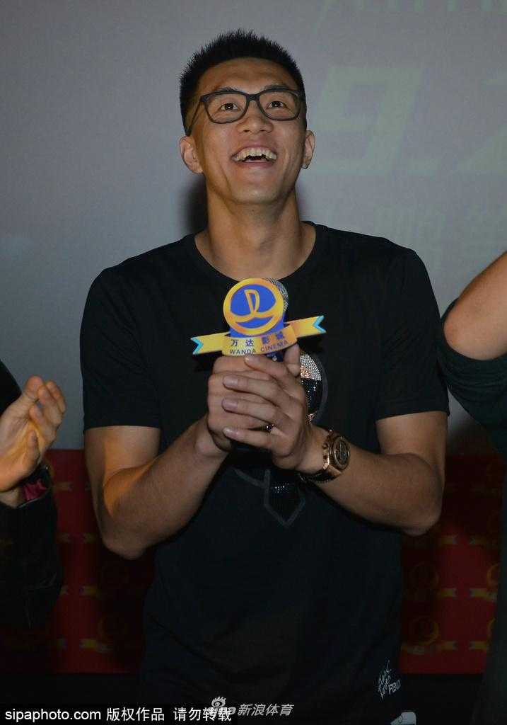 大鹏在台上拿着话筒讲话，身后的乔杉、李鸿其、曲隽希等主演一字排开，背景板上写着缝纫机乐队东北首映礼大字