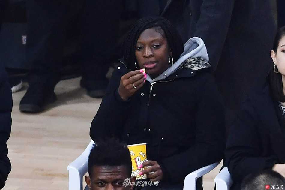 暂停间隙，亚当斯坐在替补席上喝水休息，他无意间扭头望向场边的妻子，两人目光交汇，相视一笑。这短暂而温馨的一瞬，成为激烈比赛中一抹动人的柔情。