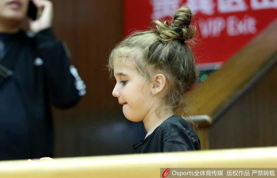 博洛西斯妻女神情专注地坐在场边看台，她们的目光紧紧追随着球场上那个作为丈夫与父亲的身影，眼神里满是骄傲与关切。