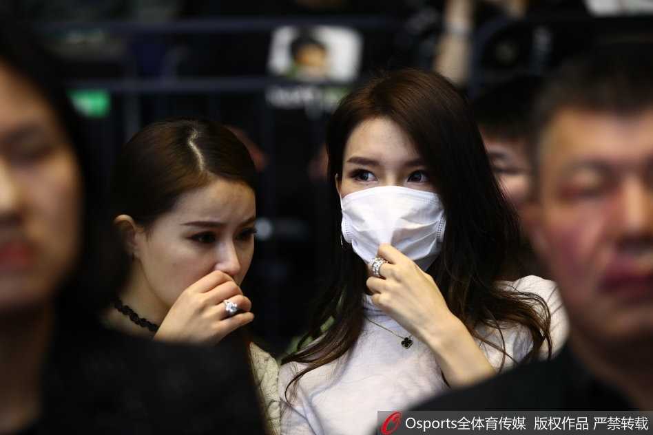 周鹏爱妻刘美身着休闲夹克搭配牛仔裤，一双修长美腿十分抢镜，她手持手机笑容灿烂地记录着场上的精彩瞬间，星味十足。