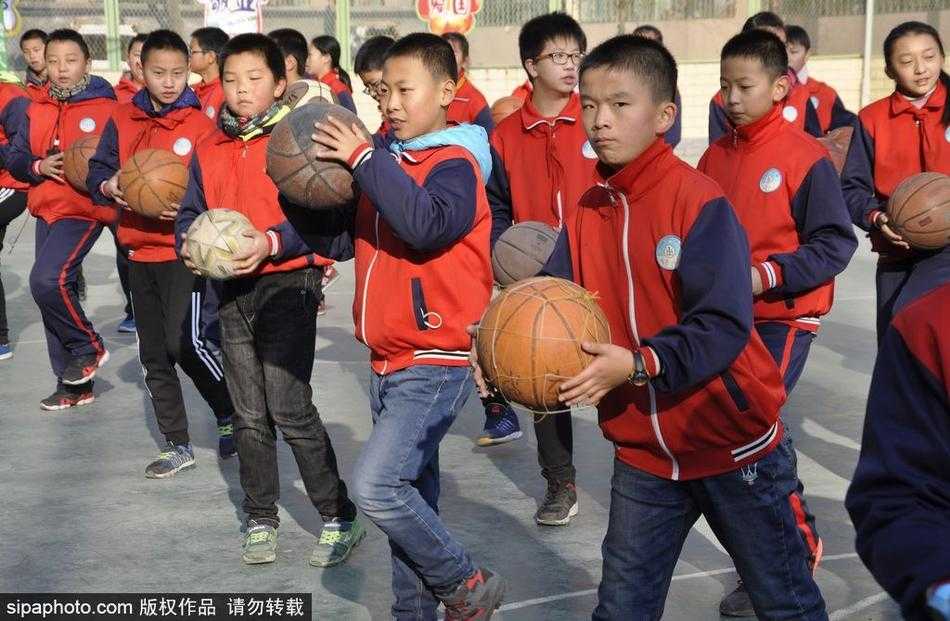 空中俯瞰的视角下，数百名学生在操场上摆开阵势，他们手中的篮球同时腾空，又同时落下，整齐得如同一个人。整个操场被巨大的节奏感所笼罩，展现出团队协作的极致之美。