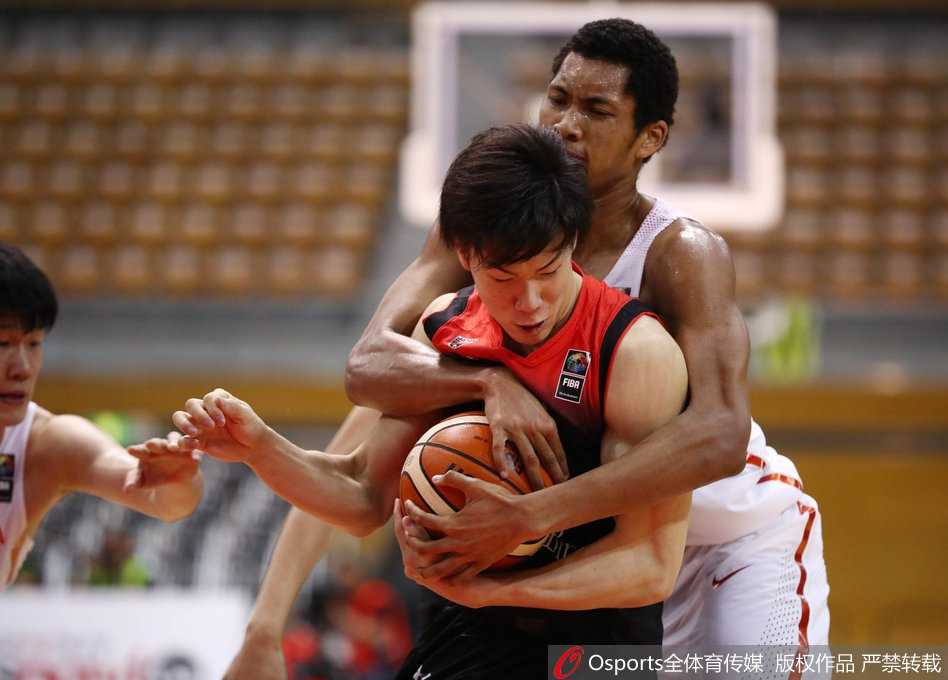 身穿白色球衣的中国国奥队员赵岩昊，在紫色球衣的日本队员严防死守下，依然自信出手，篮球在空中划出优美弧线。