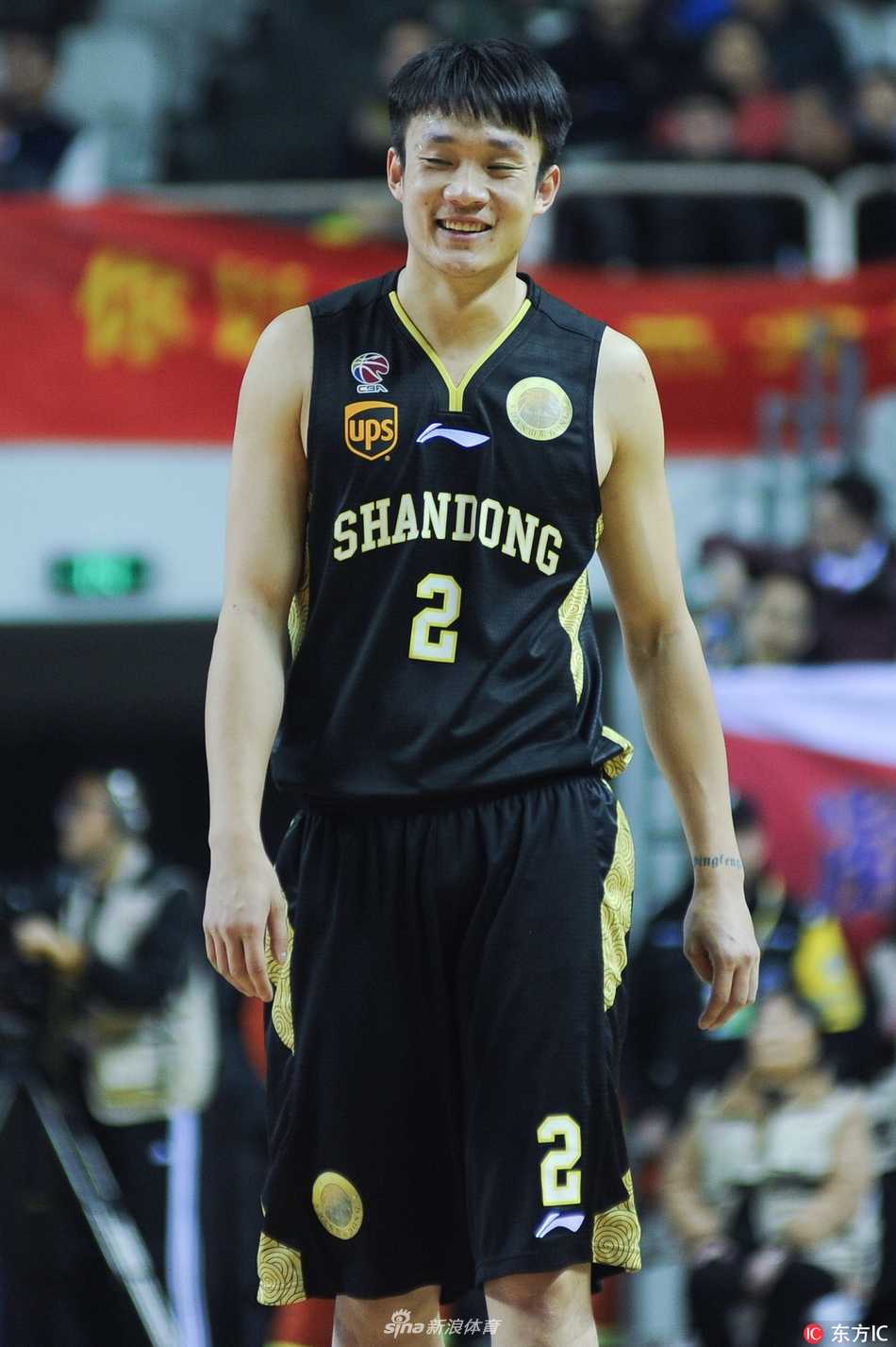 丁彦雨航在CBA比赛中高高跃起，在空中与对手发生身体对抗，依然稳稳地将球投向篮筐，展现出核心球员的大心脏