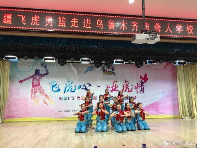 飞虎心连哑虎情:新疆男篮用篮球搭建无声世界的关爱桥梁 李根弯下腰,手把手地指导一名聋人学校的学生运球,孩子学得极其认真,眼神中充满了对篮球的热爱和对偶像的崇拜