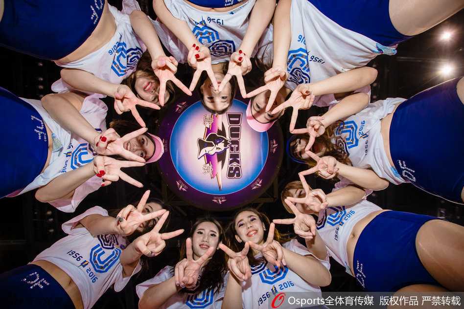 巅峰啦啦队的俏皮姑娘们围绕在霹雳鸭身旁，她们扎着可爱的丸子头，对着镜头做出 wink 表情，修长的美腿在冬日阳光下格外抢眼，青春气息扑面而来。