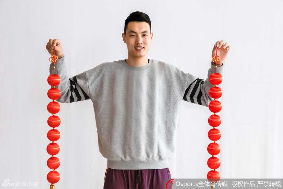 首钢雄鹰携福至 京腔年味暖人心 队友们围坐在一起,手里举着厚厚一摞红包,脸上绽放出孩子般的笑容,背景中隐约可见的冠军旗似乎也在为这喜庆时刻增添荣耀的光芒。