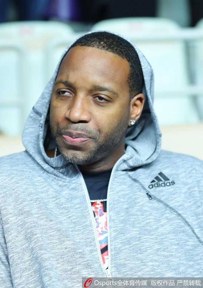 麦蒂现身源深体育馆,昔日得分王微笑见证CBA经典一战 麦蒂注视着远方,嘴角带着一丝若有若无的笑意,仿佛在回忆自己当年在这片赛场上的高光时刻,眼神深邃而富有故事感。